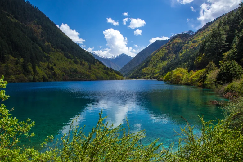 blue and green lake surrounded by mountains in the wilderness