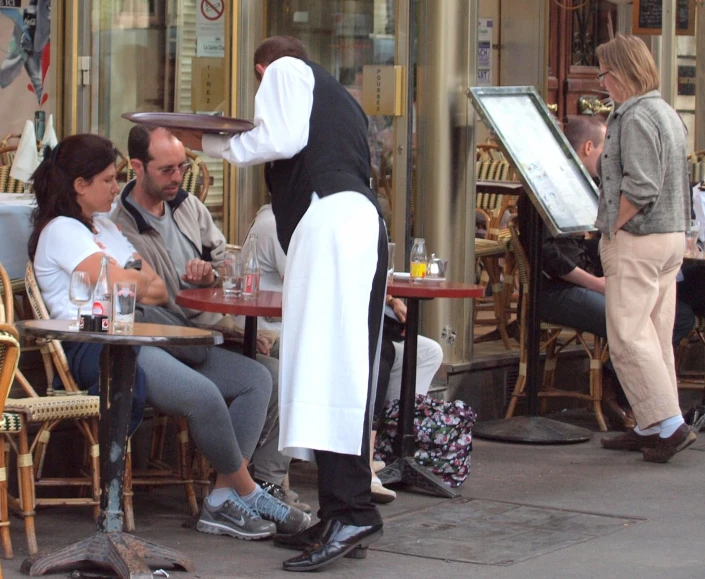 a restaurant waiter in white is cooking outside