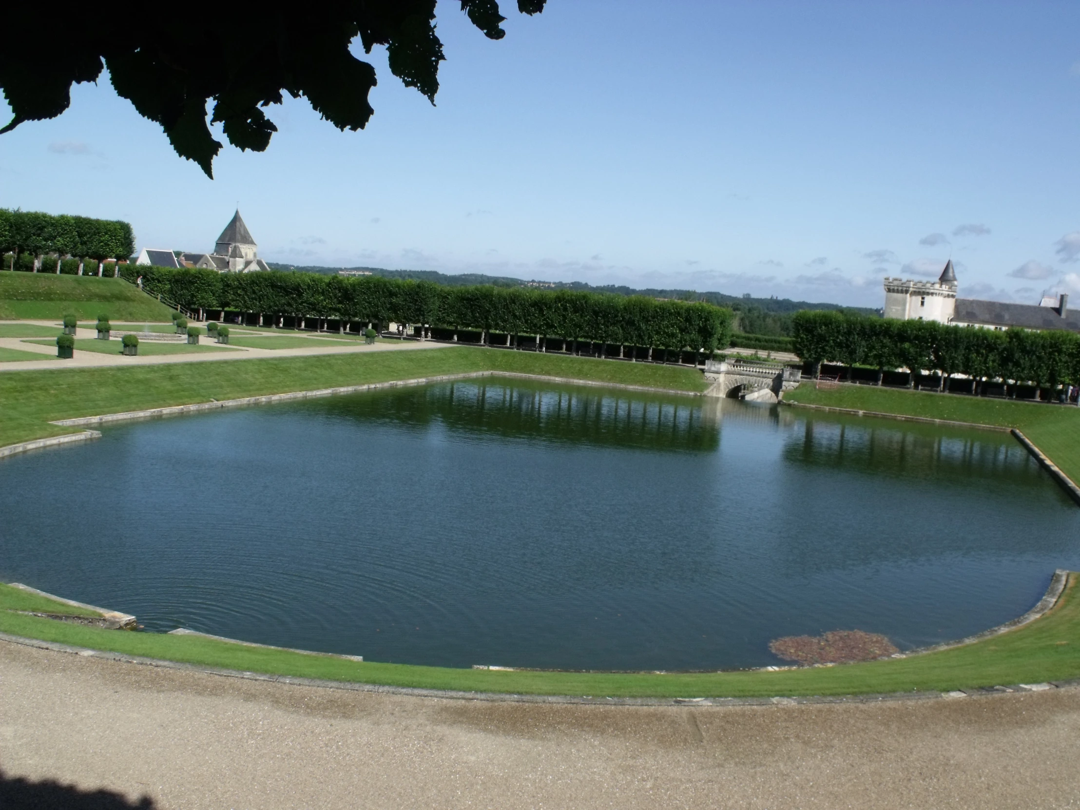 a pond with a fence and lawn on the side of it