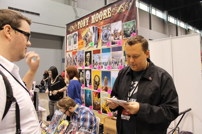 a man is holding a magazine and a woman is looking at it