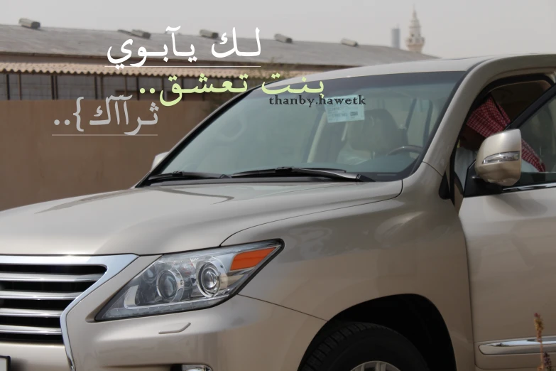 a car sitting in front of a building with an arabic sign