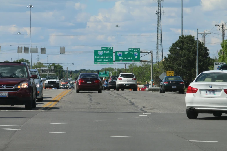 cars are going down a highway in an area with green street signs