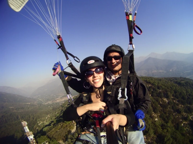 a woman holds the strings to a man attached to his parachute