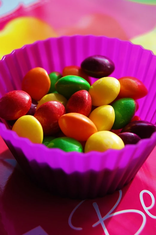 a purple bowl filled with lots of candy