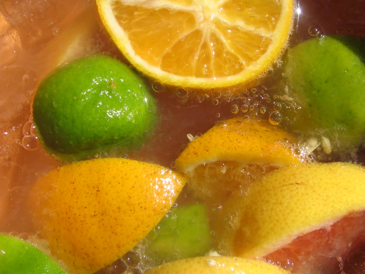 some limes and lemons are mixed in a water