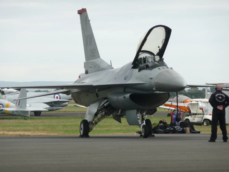 a fighter jet parked on top of an airport runway