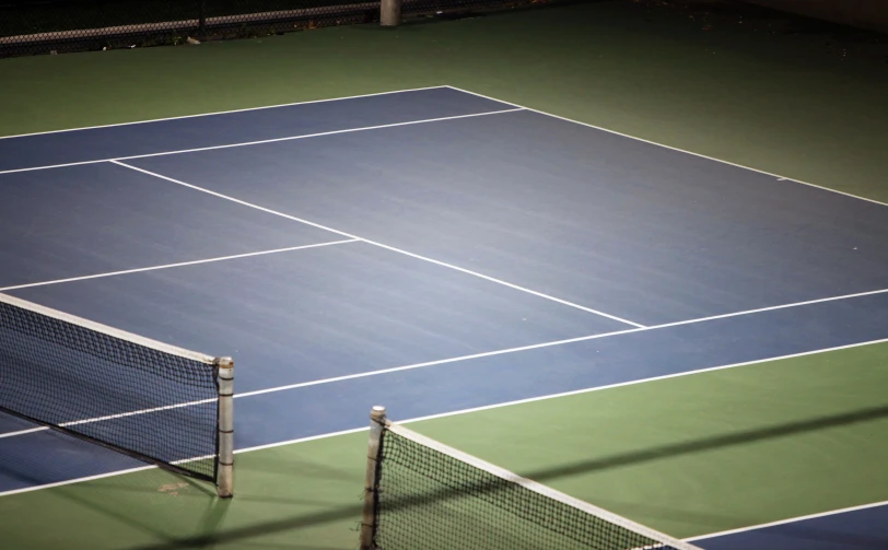 two people on a tennis court with blue and green courts