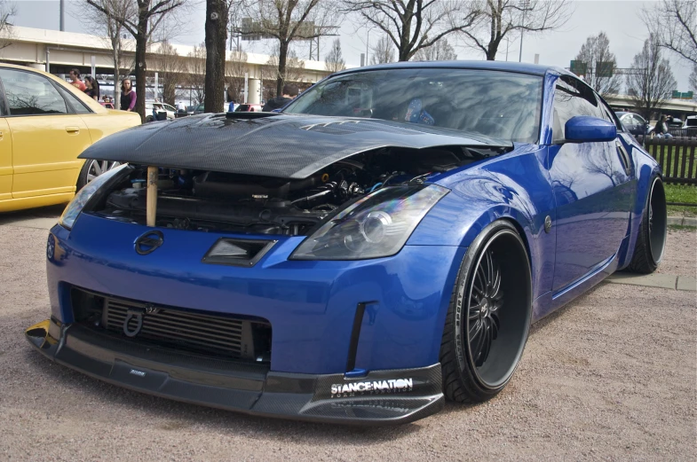 the blue nissan car is being displayed at a car show