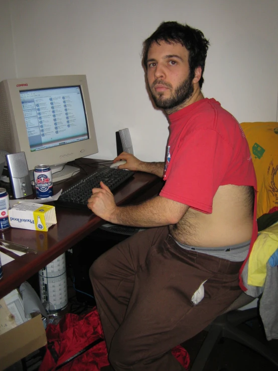 man sitting at desk using a computer and taking a picture