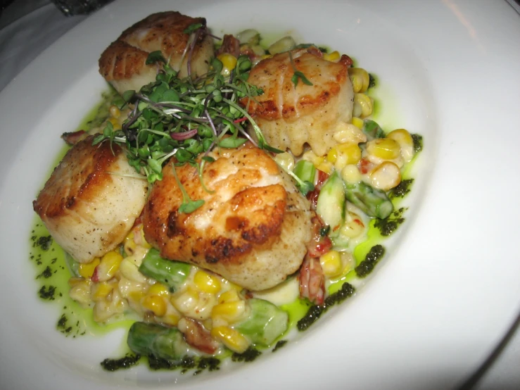 a white plate with scallops and corn on it
