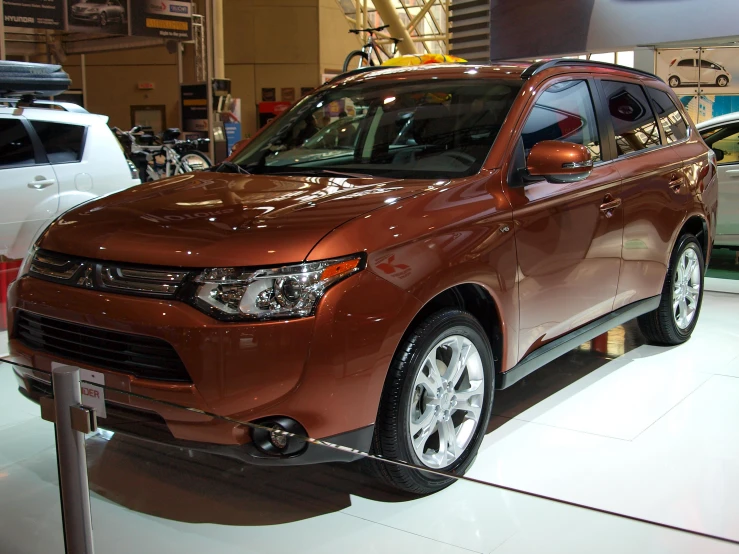 an orange car sits on display in a showroom