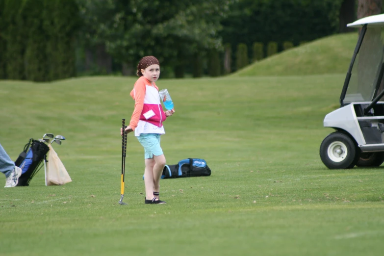 a woman playing a game of golf on the green