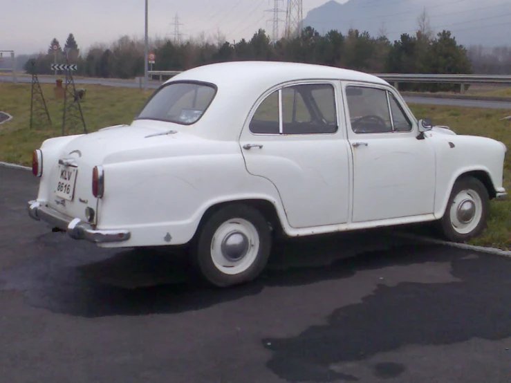 an old style car sits in the parking lot