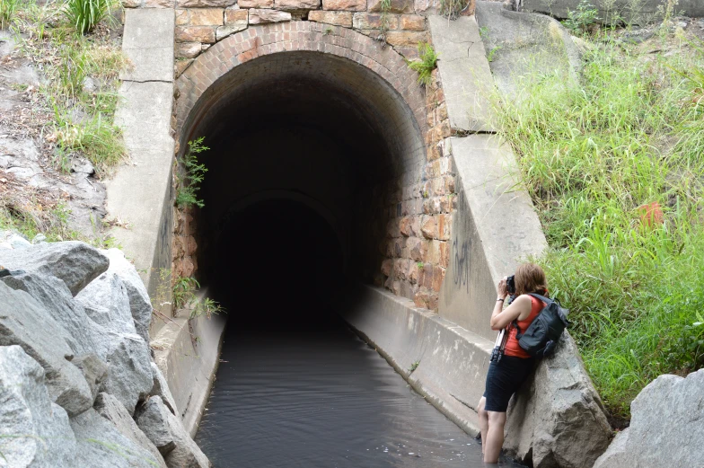 a woman that is standing next to a tunnel