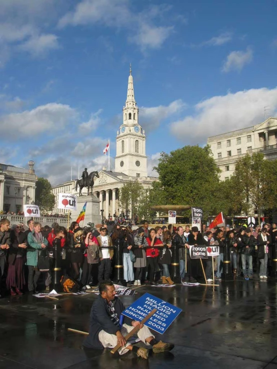 a large crowd is gathered together near a sign