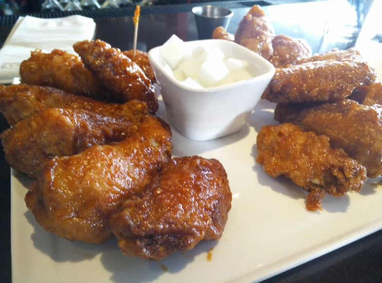 chicken wings on a plate with some dip in the middle