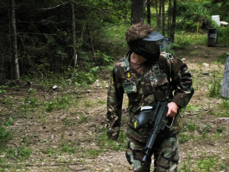 a soldier carrying a metal barrel in a camouflage suit