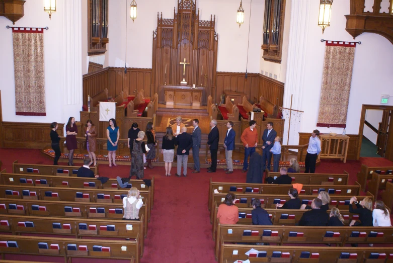 a group of people standing in an audience next to each other in a church