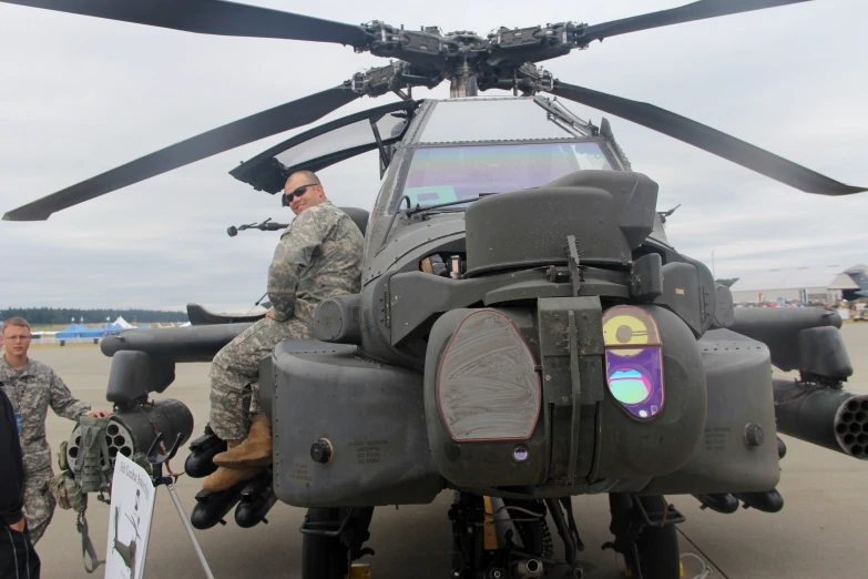 a man sitting in the cockpit of an army helicopter