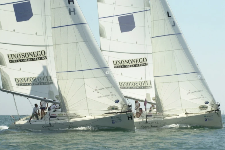 several sail boats with two on top of each other in the ocean