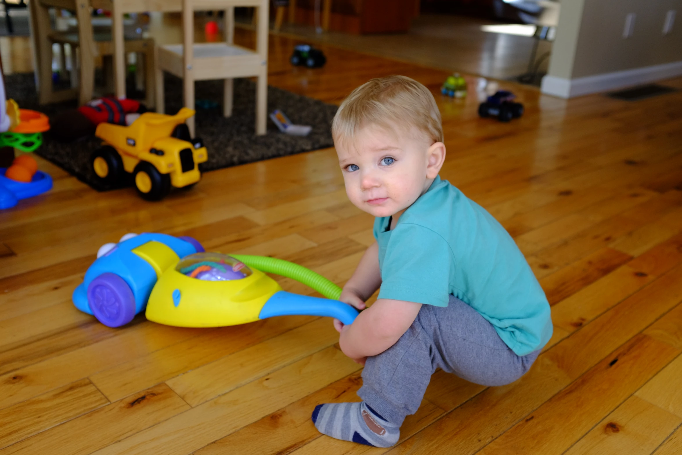 a boy holding onto a toy in the floor
