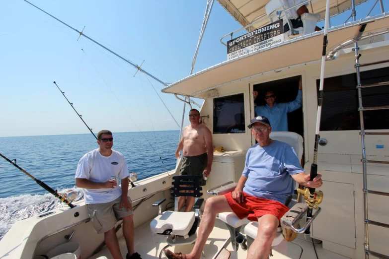 people with fishing rods on a boat near the ocean