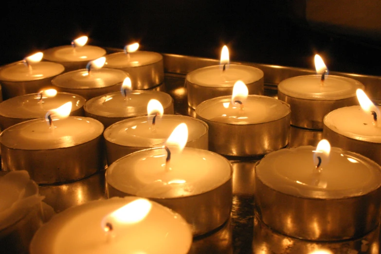 a close up of many lit candles near one another