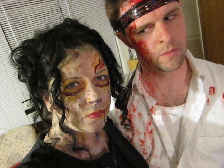 a man with makeup next to a woman with head and face paint