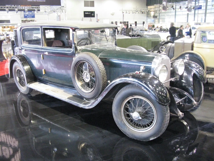 an old green car is parked inside a show room