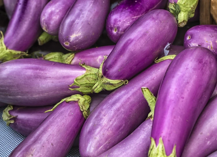 many large purple fruits are placed on a table