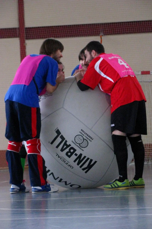 people are standing around a giant soccer ball