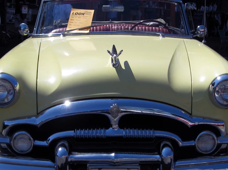 a vintage car is displayed with its hood up