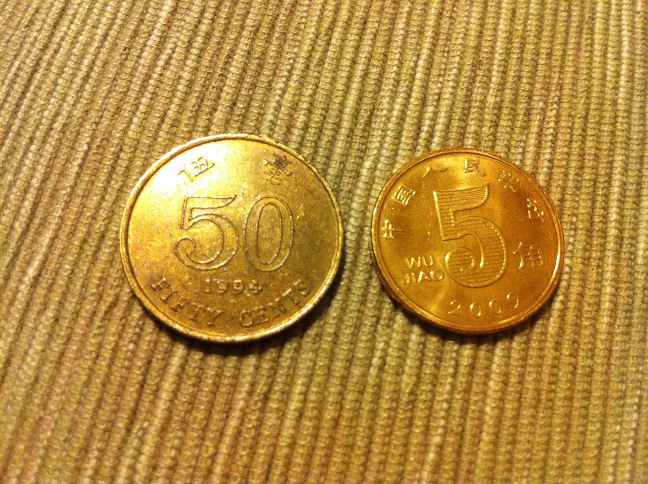 two indian five cent coins sitting on a brown fabric