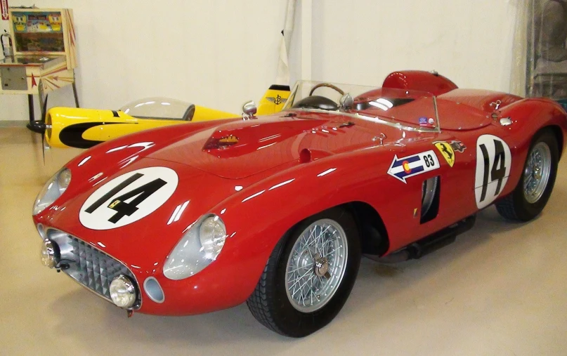 an old red car is parked in a garage