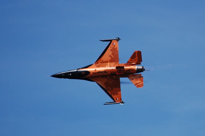 a military plane is seen flying through the blue sky