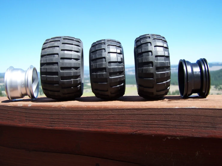 four tires and wheels sit on top of a wooden structure