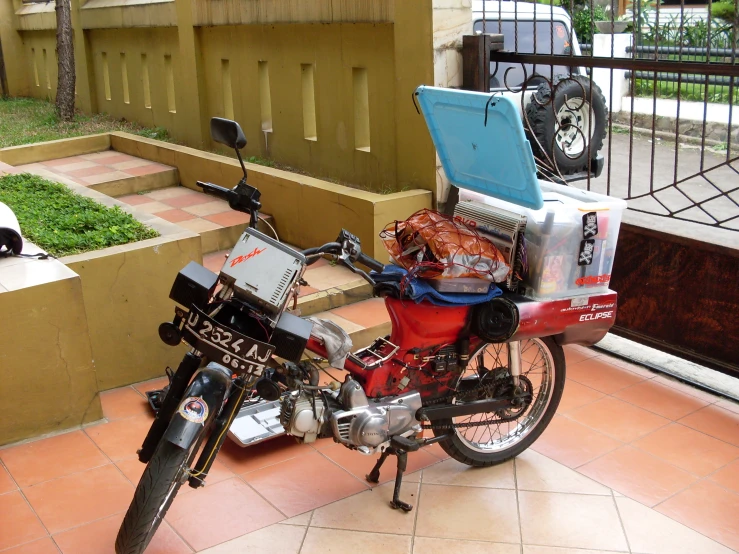 a motorcycle parked in front of a building with a laptop on the back