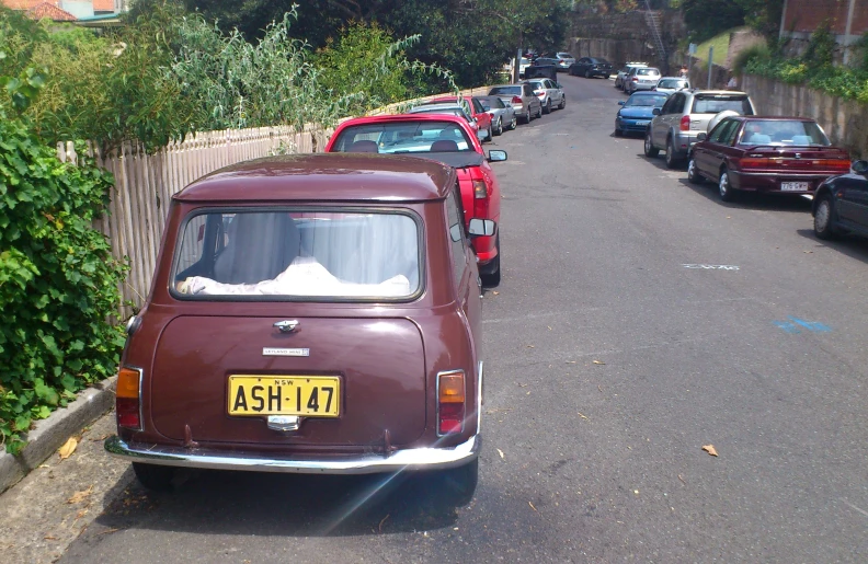 a bunch of cars that are parked by the side of the road