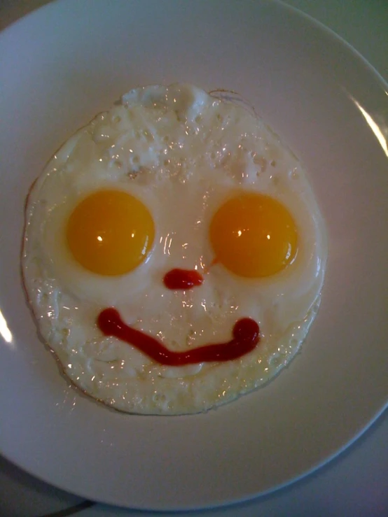 the plate is displaying the food that the face in the egg looks like it's smiling