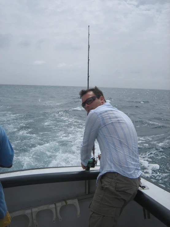 man looking into a boat with a fishing pole