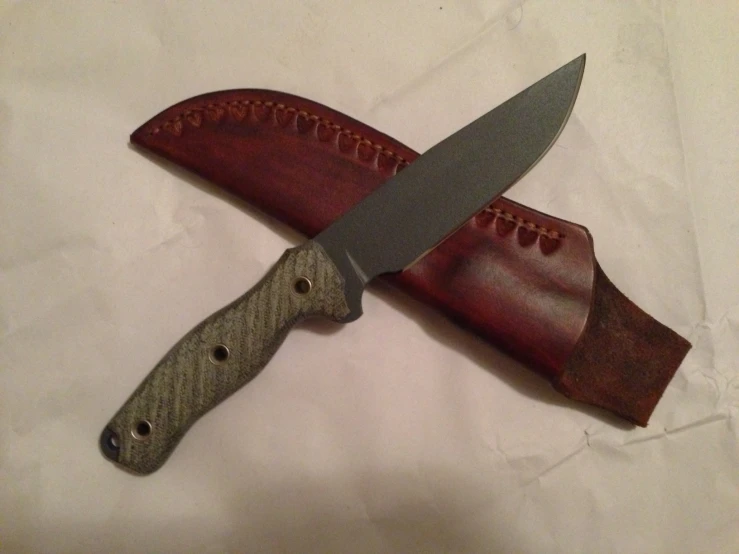 two knives with leather sheaths attached to a brown case