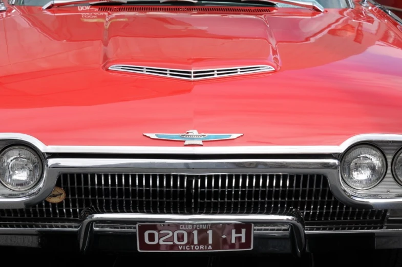a close up of the headlights on a red classic car