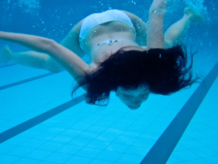the woman is swimming underwater in the pool