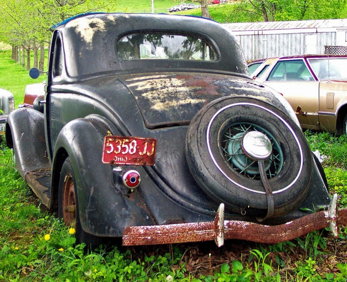 an old car parked on the grass