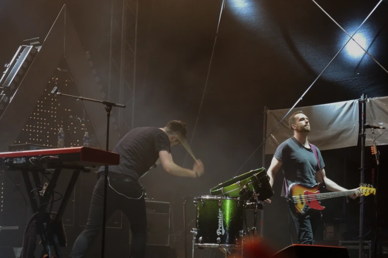 two young men are playing guitar on stage