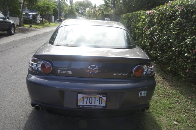 a close up view of the back of a car parked on the side of the road