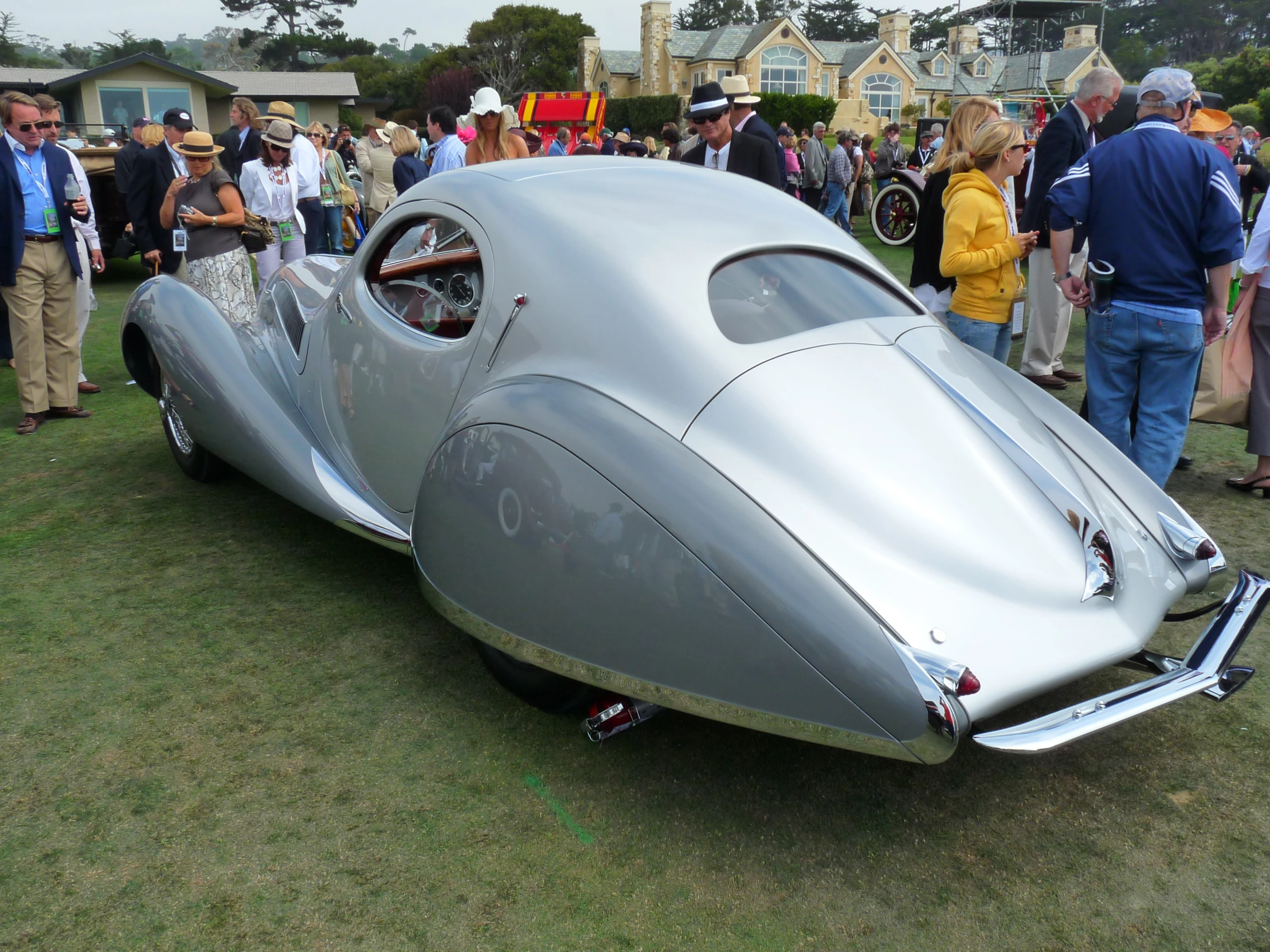 a futuristic car is parked in the grass at an outdoor show