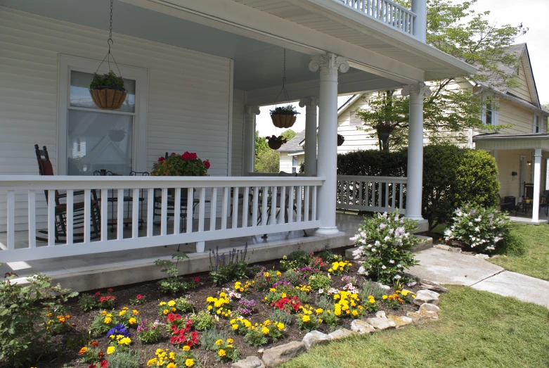 a white porch with flowers outside of it