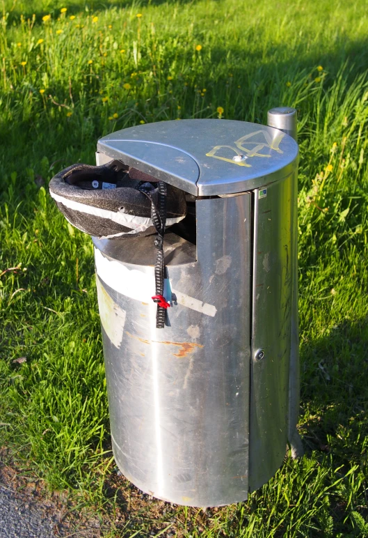 a trash can that is sitting in the grass