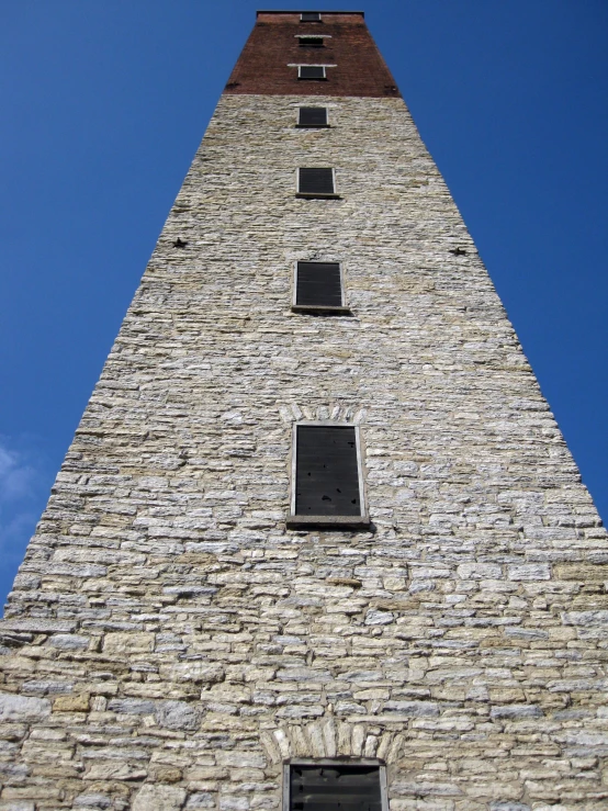 the side of a tall stone structure with two windows